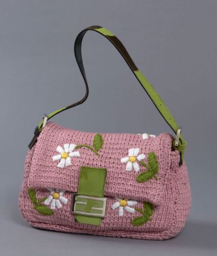 FENDI, Sac d'épaule en tricot rose à décor de paquerettes, fermoir aimanté en peau de vache teintée vert, siglée en métal argenté, anse ajustable en peau de vache verte et marron. Intérieur en satin duchesse rose, une poche zippée. Excellent état. 20 x 27