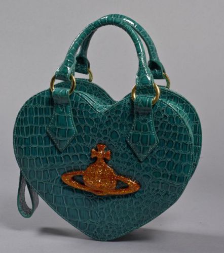 Vivienne WESTWOOD, Sac à main en cuir vernis à l'imitation du crocodile ornée d'une pendeloque en bakélite stylisée, anse bandoulière. Intérieur en toile rayée noir et blanc. Dimensions: 23 x 26.5 cm. Parfait état.