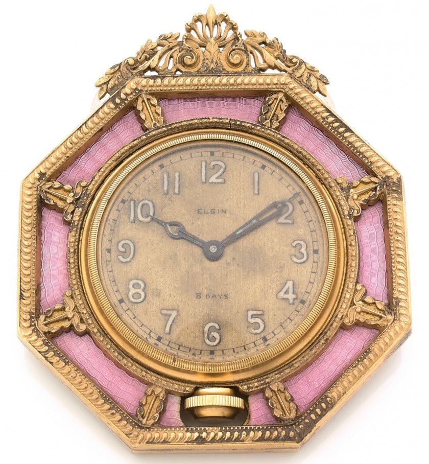 ELGIN,8 DAYS,Vers 1960,Pendule de table en métal doré et émail rose,Boîtier: octogonale, sur chevalet,Cadran: doré, chiffres arabes, minuterie chemin de fer, signé,Mouvement (à réviser): mécanique,Dim.: 10,5 x 12, 3 cm,A gilt metal and rose enamel manual 