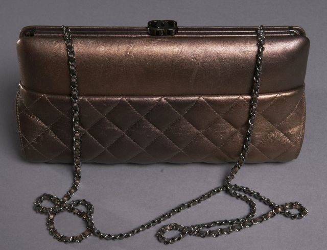 CHANEL Pochette du soir en agneau matelassé irisé aubergine, fermoir argenté, anse chaînette en cuir et métal argenté, fermoir siglé, signé (en parfait état).