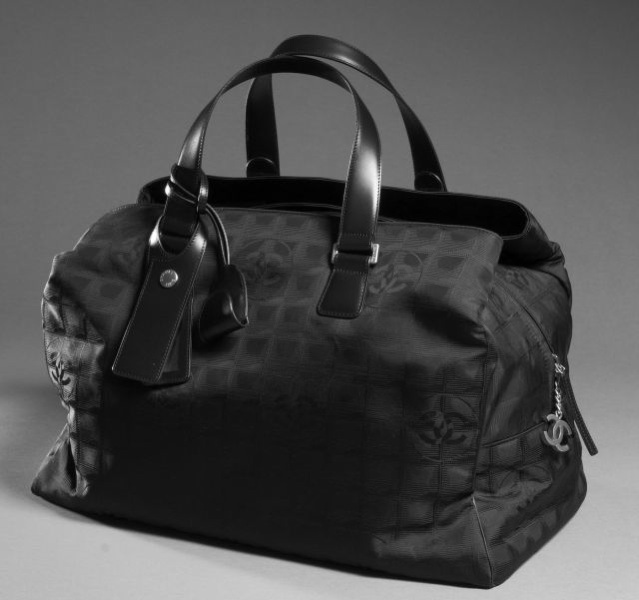 CHANEL Sac week end en nylon siglé noir à effet de carreaux, deux grandes poches extérieur zippées, cadenas - porte adresse. Etat neuf.