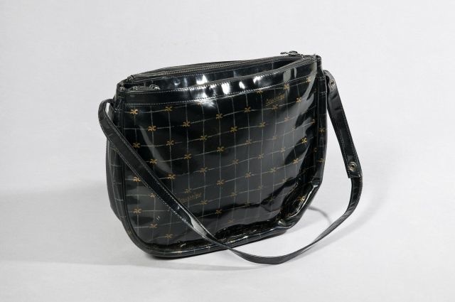 COURREGES BESACE en vinyle noir ornée du sigle doré, double poche zippée (petite patine d'usage)