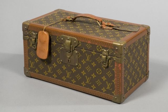 Louis VUITTON Avenue Marceau, n° 903332 (1974) BOITE-FLACONS en toile Monogram et cuir naturel, fermoir et renforts en laiton, bordures lozinées, clé sous clochette, porte-adresse, intérieur en vuittonite agrémenté d'un compartiment amovible. Dim: 40 x 20