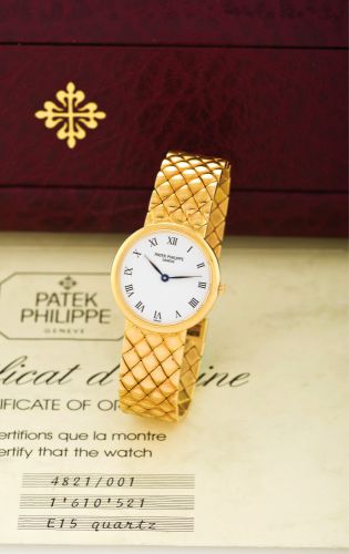 PATEK PHILIPPE REF 4821.YELLOW GOLD QUARTZ.Patek Philippe & Cie, Genève, movement No. 1610521.Ref. 4821-001, sold on August 1998..Fine, 18K yellow gold lady's quartz wristwatch with an.18K yellow gold tiled integrated Patek Philippe bracelet..Accompanied 