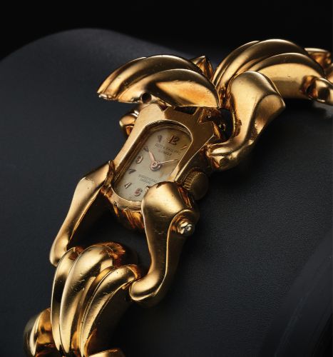 PATEK PHILIPPE REF. 2100 LADY'S.RETAILED BY SERPICO Y LAINO, CARACAS.Patek Philippe & Cie, Genève, No. 948040, case No. 647636.Ref. 2100. Made circa 1945..Very fine and unusual, oval 18K yellow gold lady's wristwatch with concealed dial, inserted in a wid