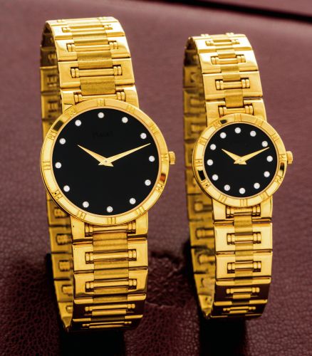 PIAGET, SET OF 2 GOLD WRISTWATCHES.Piaget. Made in the late 1980's..A set of matching his and hers 18k yellow gold quartz wristwatches with.an integrated 18k yellow gold Piaget bracelet. Accompanied by the original.fitted box and instruction booklet..A) P