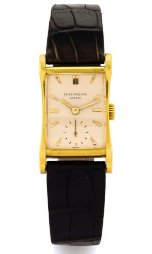 PATEK PHILIPPE REF. 2456 YELLOW GOLD.Patek Philippe, Genève, movement No. 973589, case No..665480, Ref. 2456. Made circa 1950..Very fine and rare, rectangular curved, flared, 18K yellow.gold wristwatch with an 18K yellow gold Patek Philippe.buckle..Dial, 