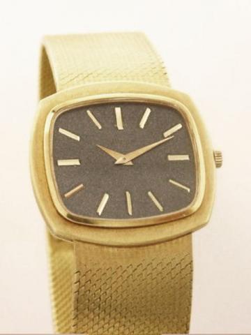 Piaget, Ref. 9431. Produced in the 1970's. Fine, cushion shaped, 18K yellow gold gentleman's wristwatch with an 18K yellow gold integrated and linen textured Piaget bracelet.