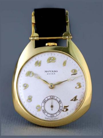 Movado, Swiss, Ref. 7341. Produced in the 1940's.Fine and unusual, asymmetric, keyless, 18K yellow gold pocket watch with an 18K yellow gold monogrammed shield on a black fob.