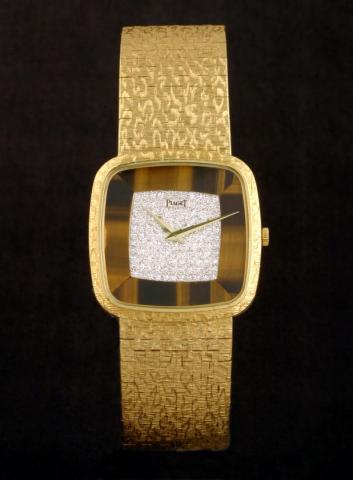 Piaget, Ref. 9771. Produced in the 1970s.Fine and elegant, cushion-shaped, 18K yellow gold, diamonds and tiger's eye gentleman's wristwatch with an integrated and textured 18K yellow gold Piaget bracelet.