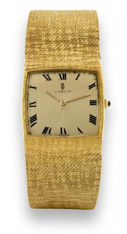 Yellow Gold Buckingham.Corum, Ref. 8521. Made in the 1980s..Fine, cushion-shaped, 18K yellow gold wristwatch with a wide.integrated 18K yellow gold textured Corum bracelet. Accompanied.by a fitted box..To be sold without reserve