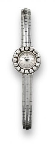 Omega, movement.No. 18411736, case No. 497256..Made in the 1950's..Fine and elegant, diamond-set 18K white.gold lady's wristwatch with an Omega.18K white gold integral bracelet..To be sold without reserve