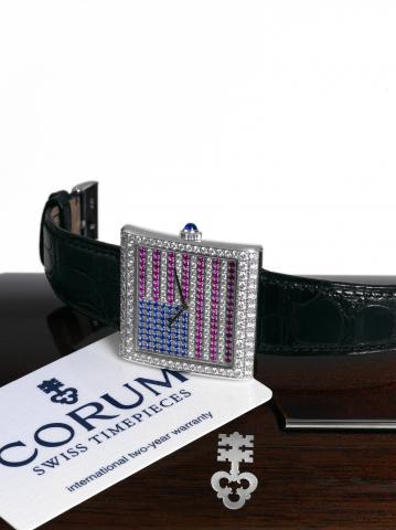 Corum _ United We Stand _ In God We Trust.Corum, Buckingham, No. 005/25, case No. 760178, Ref..157.191.69. Made in a limited edition of 25 pieces circa 2006..Fine and unusual, large, square, 18K white gold wristwatch.set with diamonds, sapphires and rubie