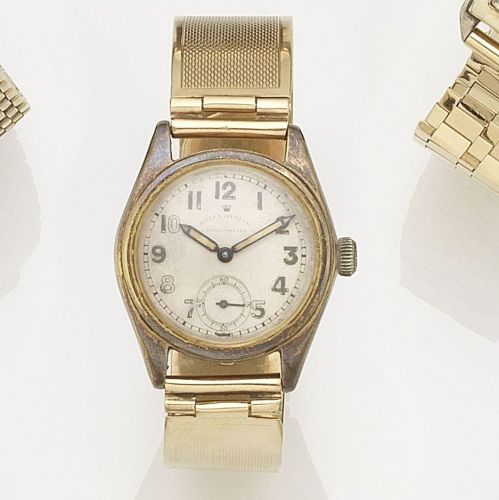Rolex. An 18K gold manual wind watch with later 9K gold bangle
