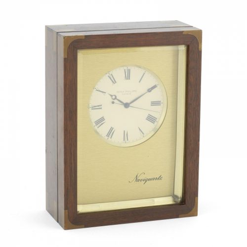 Patek Philippe. A brass and plastic cased quartz desk clock with mahogany presentation box