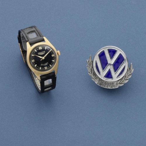 Laco Sport. A gold plated manual wind commemorative wristwatch and a 100.000 Kilometer Volkswagen badge