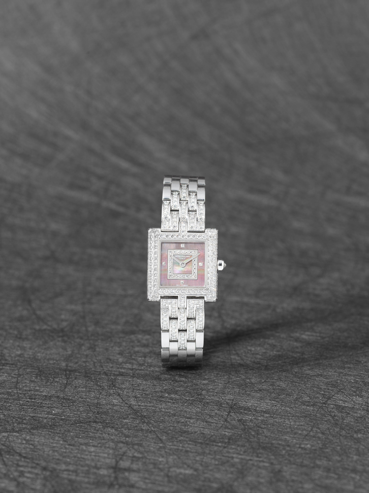 Patek Philippe. A lady's fine 18K white gold, diamond set quartz bracelet watch with mother of pearl dial