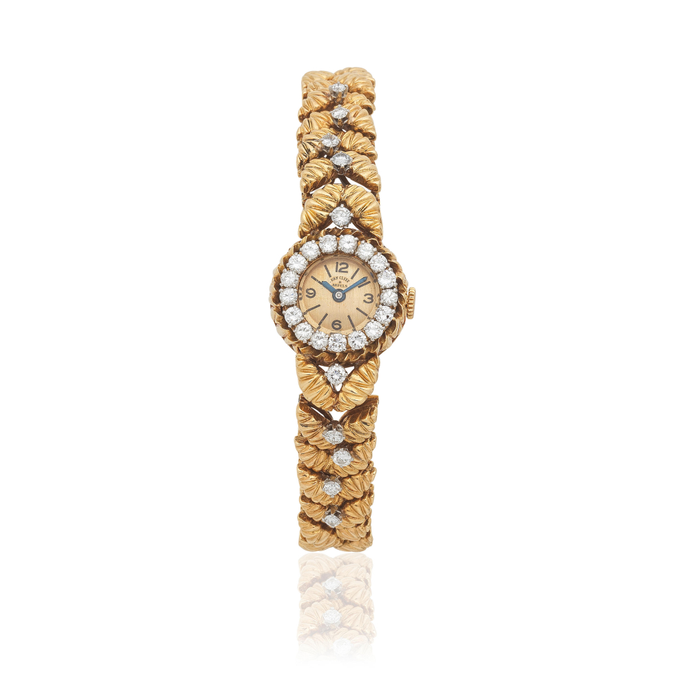 Movado for Van Cleef & Arpels. A lady's 18K gold diamond set manual wind bracelet watch