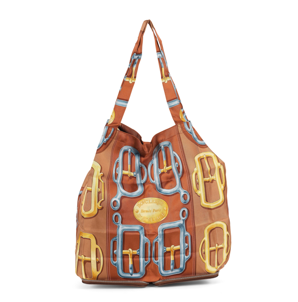 HERMES. Sac cabas Silky Pop en twill de soie imprimée à motif Bouclerie d'Attelage et cuir de buffle gold.