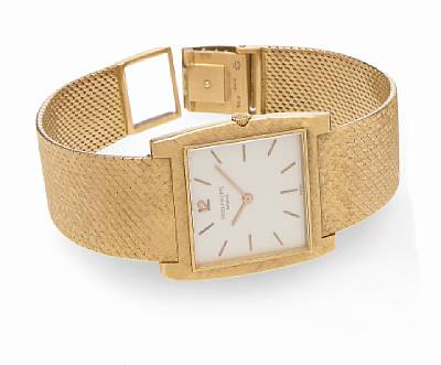 Patek Philippe. An 18k gold cushion cased wristwatch on bracelet