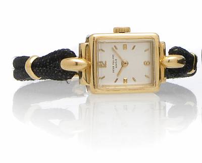 Patek Philippe. A Lady's 18k gold rectangular wristwatch on cord strap