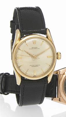 Rolex. A 14k gold self-winding wristwatch with curved shoulders
