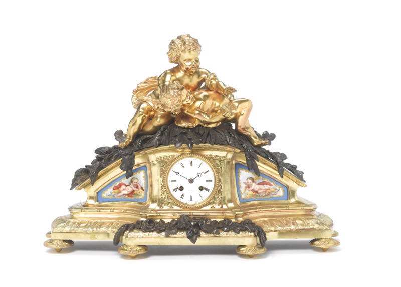 A large late 19th century French bronze and ormolu mantel clock with cherubs and porcelain panels