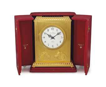 Patek Philippe. A heavy and rare rectangular solar-powered gilt brass table clock with the heads of two horses and a box