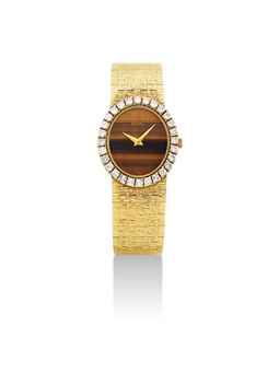 PIAGET. A LADY'S 18K GOLD AND DIAMOND-SET OVAL BRACELET WATCH WITH TIGER'S EYE DIAL