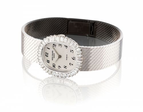 PATEK PHILIPPE. A LADY/bb’/bbS FINE AND ELEGANT 18K WHITE GOLD AND DIAMOND-SET OVAL BRACELET WATCH WITH BREGUET NUMERALS/b