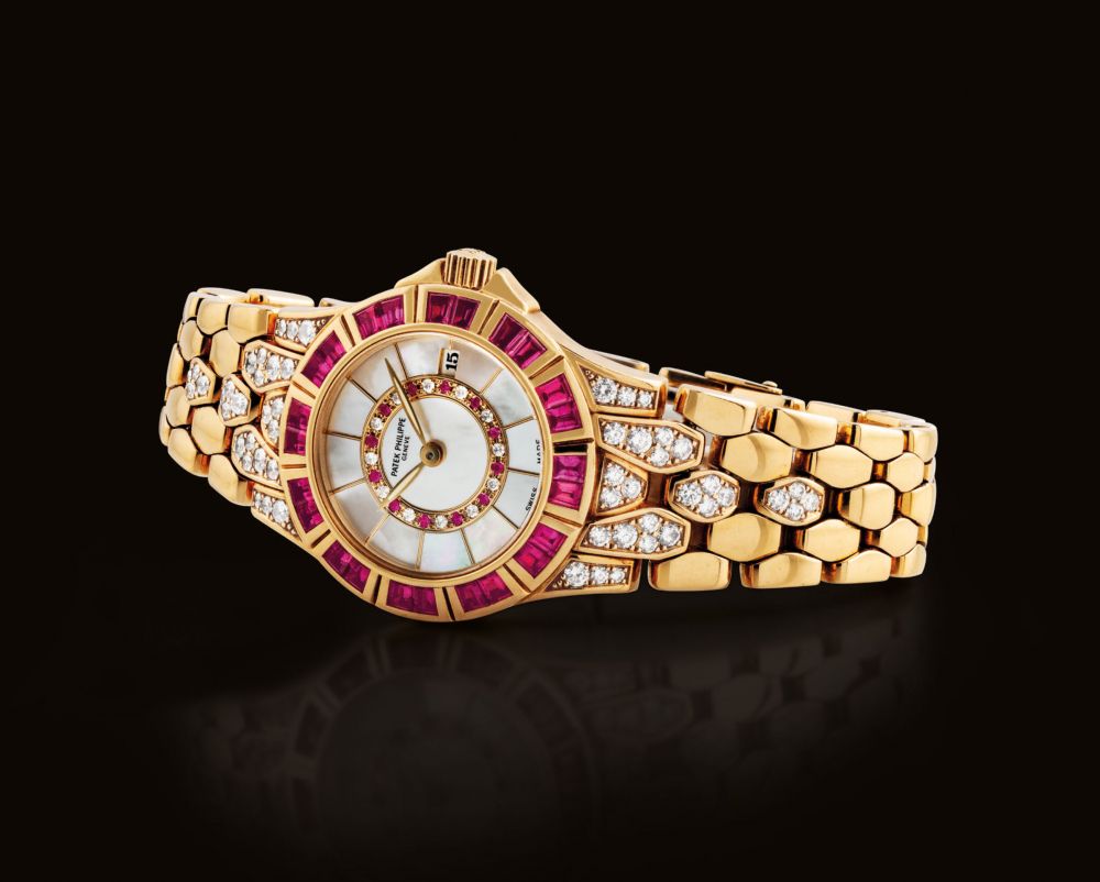 PATEK PHILIPPE. A LADY'S FINE AND ATTRACTIVE 18K GOLD, DIAMOND AND RUBY-SET BRACELET WATCH WITH DATE AND MOTHER-OF-PEARL DIAL
