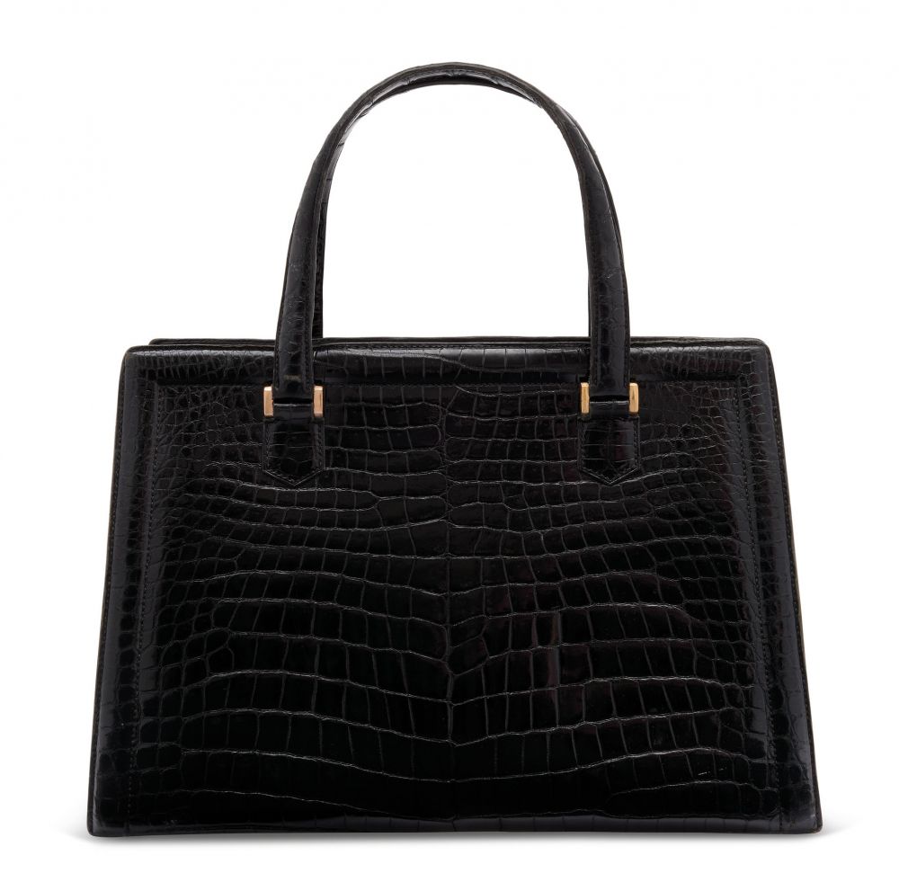 A SHINY BLACK POROSUS CROCODILE PULLMAN WITH GOLD HARDWARE