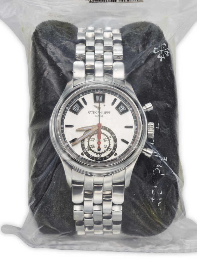 PATEK PHILIPPE. A SPORTY AND FACTORY SEALED STAINLESS STEEL AUTOMATIC ANNUAL CALENDAR FLYBACK CHRONOGRAPH WRISTWATCH WITH POWER RESERVE, DAY/NIGHT INDICATOR AND BRACELET