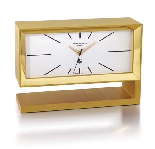 Patek Philippe. An unusual and rare gilt brass quartz presentation desk clock with sweep centre seconds