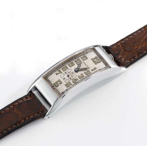 Movado. An early and unusual large 14K white gold rectangular curved hinged wristwatch