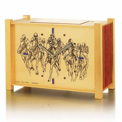 PATEK PHILIPPE. A RARE AND UNUSUAL GILT BRASS, WOOD AND LAPIS LAZULI-SET SOLAR POWERED DESK CLOCK WITH HORSE RACING ENGRAVED DIAL