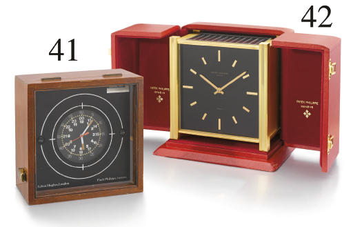 Patek Philippe. A fine gilt brass square solar-powered desk clock with black dial and box