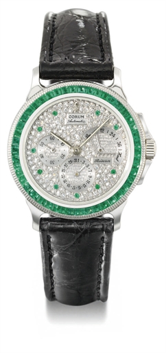 Corum. A fine and rare platinum, emerald and diamond-set automatic wristwatch with date and power reserve