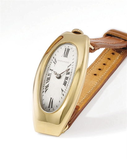 Movado. An unusual, large and early 18K gold tonneau-shaped curved hinged wristwatch