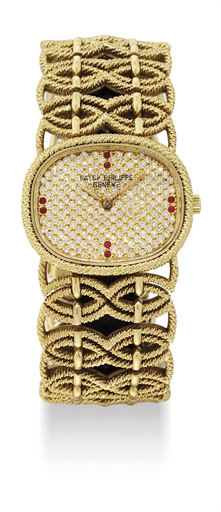 PATEK PHILIPPE. A LADY'S FINE 18K GOLD, DIAMOND AND RUBY-SET OVAL WRISTWATCH WITH BRACELET