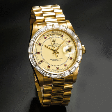 ROLEX - A YELLOW GOLD, DIAMOND AND RUBY SET AUTOMATIC SWEEP SECONDS WRISTWATCH WITH DAY, DATE AND BRACELET CIRCA 1983 REF 18168 DAY-DATE