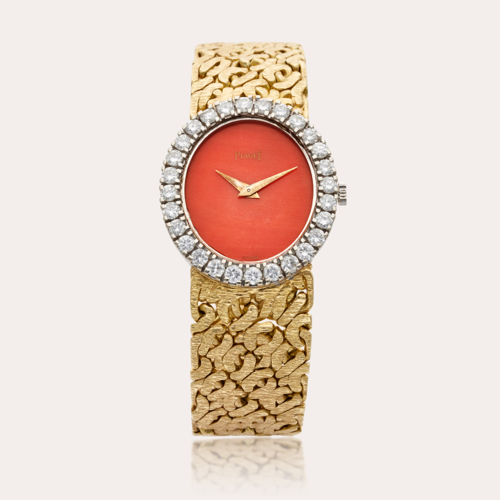 Piaget Reference 9814 N66 | A white and yellow gold and diamond-set oval bracelet watch with coral dial, Circa 1970